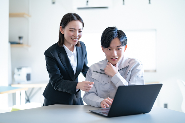 職場で採用や情報について打ち合わせをする社員